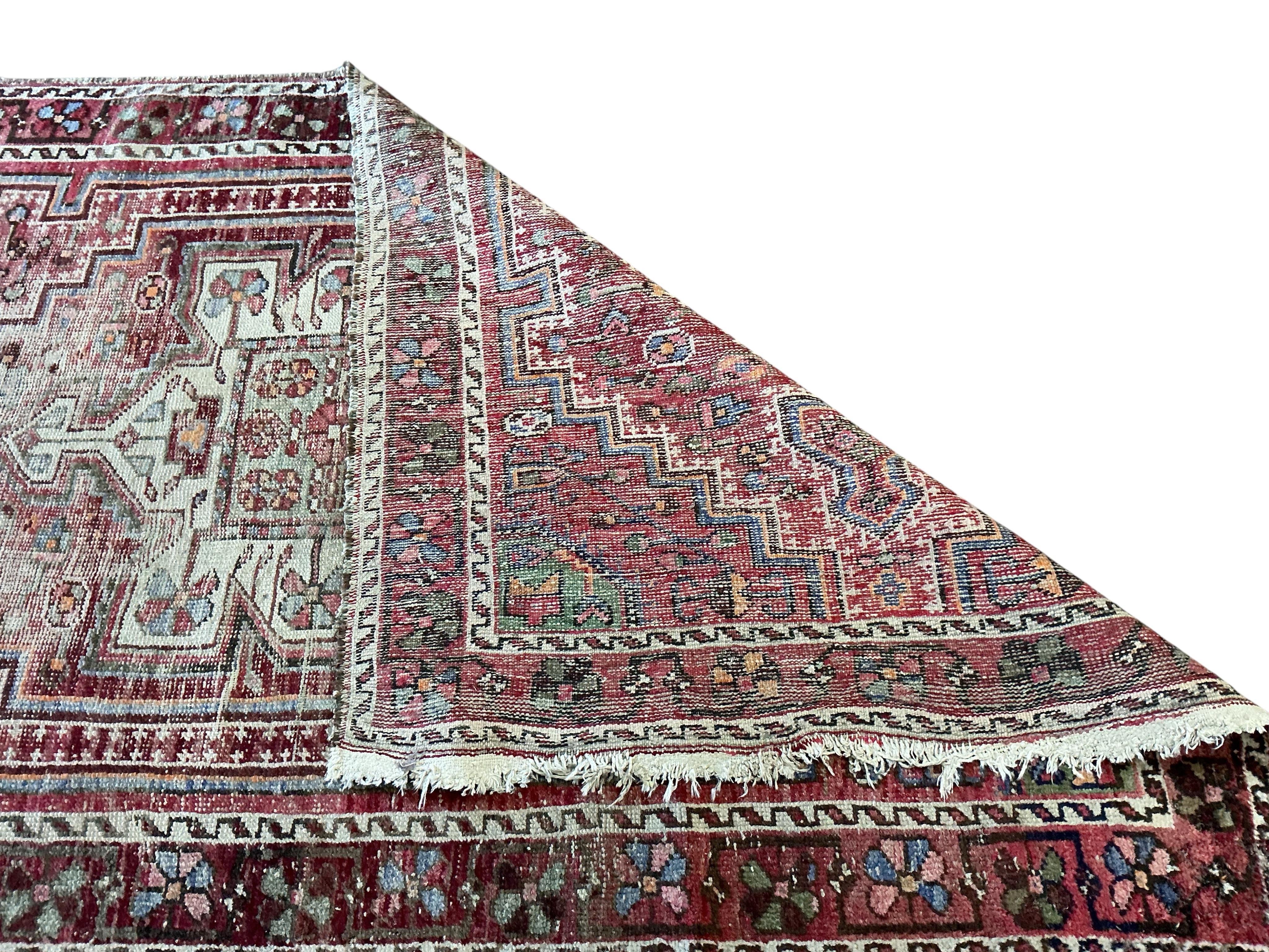 A Caucasian faded red ground rug, 210 x 126cm (severely worn)